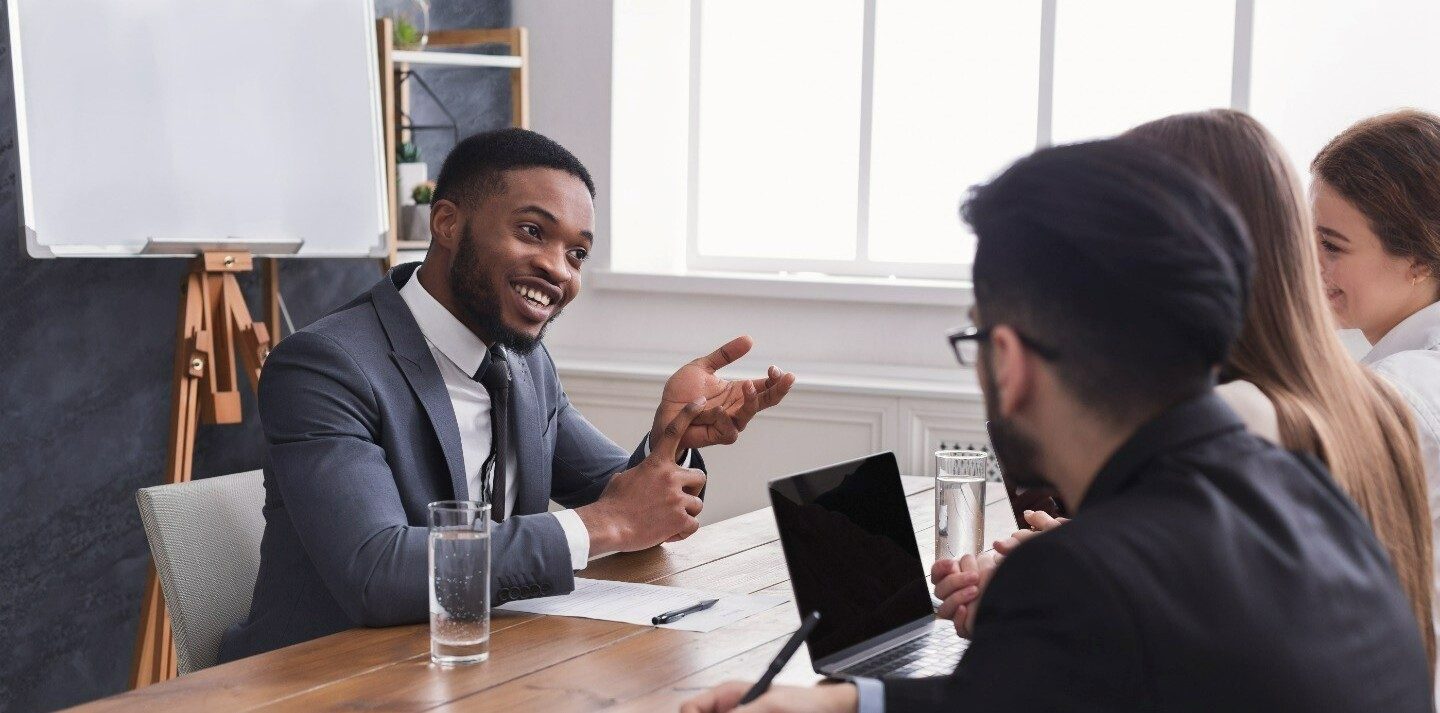 Group of business professionals chatting together around a table