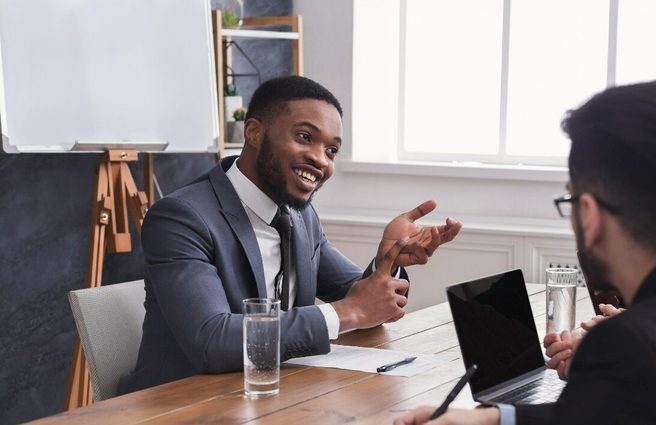 Group of business professionals chatting together around a table